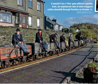  ?? GRAHAM NUTTALL ?? It wouldn’t be a ‘Ffes’ gala without a gravity train. An unpowered rake of slate waggons rattles downhill through Penrhyn on October 11.