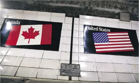  ?? PHOTOS: DAN JANISSE ?? The flags of Canada and the United States mark the midway point in the Windsor/Detroit tunnel — a main internatio­nal crossing for thousands of commuters and tourists each day. Those crossings could become more difficult if U.S. President Donald Trump has his way.