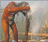  ??  ?? A Hindu Holy man smears ash on his hair after a holy dip at Sangam.