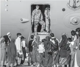  ?? AIRMAN 1ST CLASS KYLIE BARROW/AIR FORCE ?? U.S. Air Force personnel board evacuees onto a C-17 transport plane Aug. 22 at al-Udeid base in Qatar for the next leg of their journey.