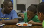  ?? ERIC BONZAR—THE MORNING JOURNAL ?? Eleven-year-old Teon Lenor cuts tomatoes for salsa as Abraham Thomas, 12, looks on, July, 27.