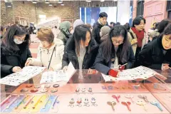  ??  ?? Fans of K-pop idol boy band BTS at a pop-up store selling BTS goods in Seoul.