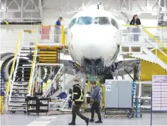  ?? — Reuters ?? Employees work on an Airbus A220-300 at their facility in Mirabel, Quebec, Canada.