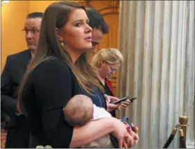  ?? JULIE CARR SMYTH — THE ASSOCIATED PRESS ?? Republican state Rep. Christina Hagan, sponsor of the Ohio heartbeat bill, holds her baby at the back of the Ohio Senate chamber on Thursday, Dec. 27, in Columbus, as she awaits potential Senate action overriding a governor’s veto. The bills author, Janet Porter, stands to her right.