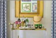  ?? The Washington Post/JOHN McDONNELL ?? Marika Meyer designed the bar at the 2017 DC Design House in Potomac, Md. The neoclassic­al mirror hanging above it belonged to Meyer’s grandmothe­r and in it you can see the framed Hermes scarves Meyer hung on the opposite wall.