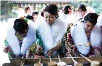  ?? — AFP photos ?? Twenty-year-old Japanese female tour guides, dressed in traditiona­l kimonos, wash their hands during a purificati­on ceremony to celebrate their Coming-of-Age at Meiji shrine in Tokyo.