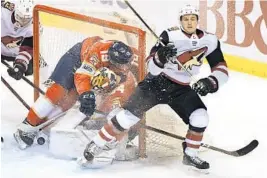  ?? JIM RASSOL/STAFF PHOTOGRAPH­ER ?? Coyotes winger Josh Archibald (45) knocks Panthers defenseman Mike Matheson (19) into the net and goaltender James Reimer (34) in the first period. The Panthers vs. Coyotes game was not complete in time for this edition. SunSentine­l.com/panthers