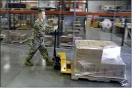  ?? DARRON CUMMINGS, FILE - THE ASSOCIATED PRESS ?? In this March 26 file photo, an Indiana National Guardsman pushes a pallet of medical supplies to be delivered in Indianapol­is. An Associated Press analysis shows states spent more than $7 billion this spring buying personal protective equipment like masks, gloves and gowns as well as vital medical devices like ventilator­s.