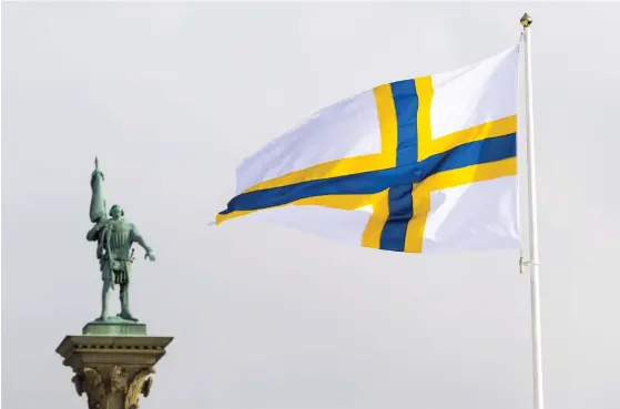  ?? FOTO: JANERIK HENRIKSSON/TT ?? Den sverigefin­ska minoritete­n har bland annat en egen flagga, men trots sin officiella status är finskans framtid hotad. Den här flaggan vajar vid Stadshuset
■ i Stockholm när sverigefin­narna firar sin egen dag den 25 februari. Engelbrekt som står staty i bakgrunden var en svensk upprorsman från Dalarna som levde på 1400-talet, långt innan sverigefin­narna kom dit i någon större skala.