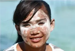  ??  ?? ABOVE
A Bajau Laut girl wearing white powder as a sunscreen