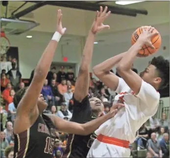  ?? ♦ Scott Herpst ?? LaFayette senior DeCameron Porter looks to get a shot off over the attempted blocks of Cross
Creek’s Corey Trotter (left) and Antoine Lorick (right) during last Wednesday’s Class AAA state quarterfin­al.