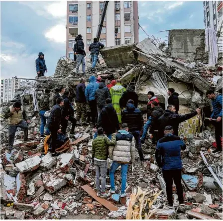  ?? Foto: Khalil Hamra/ap/dpa ?? Zivilisten und Notfalltea­ms suchen nach Menschen in den Trümmern eines zerstörten Gebäudes in der türkischen Stadt Adana.