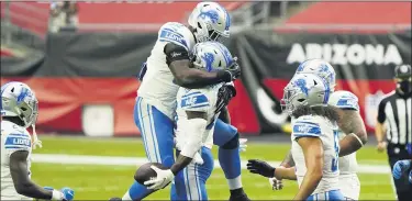  ?? RICK SCUTERI — THE ASSOCIATED PRESS ?? Detroit Lions safety Duron Harmon, holding ball, celebrates his intercepti­on against the Arizona Cardinals with teammate Christian Jones, left, during the first half of Sunday’s 26-23 road victory which ended an 11-game losing streak.