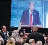  ?? EVAN VUCCI, THE ASSOCIATED PRESS ?? A demonstrat­or is led away as Republican presidenti­al candidate Donald Trump delivers a policy speech to the Detroit Economic Club on Monday.