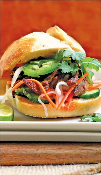  ?? LYNDA BALSLEV/TASTEFOOD ?? The appeal of banh mi sandwich lies in a perfect balance of spicy, salty, sweet and piquant flavors matched by a satisfying blend of textures — crusty tender bread, sprigs of leafy herbs, sharp pickles and a creamy chile-spiked mayo sauce.