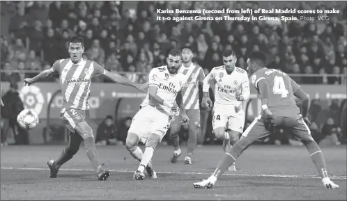  ??  ?? Karim Benzema (second from left) of Real Madrid scores to make it 1-0 against Girona on Thursday in Girona, Spain.