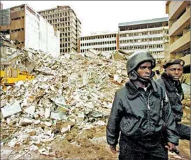  ?? ALEXANDER JOE/GETTY-AFP PHOTO ?? Security guards keep watch after a 1998 blast hit the U.S. Embassy in Nairobi, Kenya. Retaliator­y U.S. airstrikes may have strengthen­ed ties between the Taliban and al-Qaida.