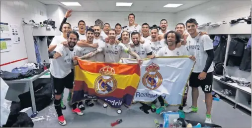  ??  ?? EXULTANTES. Los jugadores del Real Madrid celebraron la victoria en el vestuario del Calderón con una bandera de España y otra del Madrid.