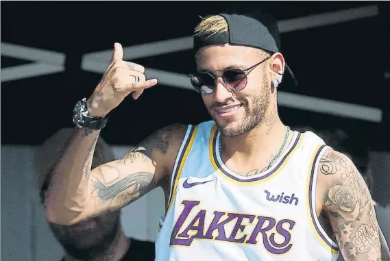  ?? FOTO: EFE ?? Preocupado no parece Neymar posó con la camiseta de los Lakers ayer durante su visita al Mundial de Surf en Portugal