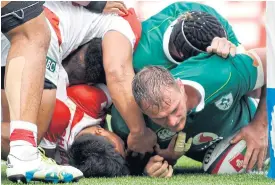  ??  ?? Ireland’s Rhys Ruddock, right, scores a try against Japan.