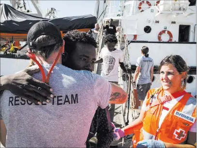  ?? Valerio Nicolosi ?? The Associated Press Migrants disembark Thursday from the Open Arms vessel in Algeciras, Spain, after being rescued Aug. 2 off the coast of Libya.