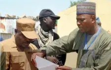  ??  ?? Government house staff with a volunteer leader verifying names during the payment of outstandin­g allowances