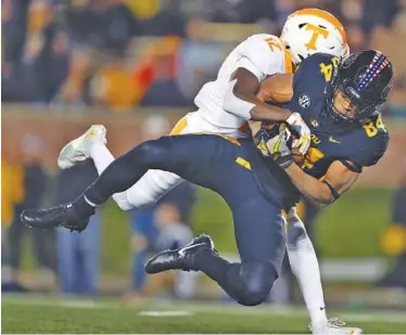  ?? THE ASSOCIATED PRESS ?? Missouri wide receiver Emanuel Hall falls into the end zone after catching a pass for a touchdown as Tennessee defensive back Emmanuel Moseley tries to stop him in the first half of the host Tigers’ 50-17 victory.