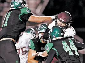  ??  ?? Chesterton quarterbac­k Chris Mullen gets sacked by Valparaiso’s Cooper Jones (11) and Mason Jones (44) during their game on Friday.