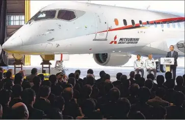  ?? Toshifumi Kitamura AFP/Getty Images ?? A MITSUBISHI Regional Jet is unveiled in 2014 at the Nagoya airport by executives from All Nippon Airways and Mitsubishi Heavy Industries. The jetliner is finally undergoing certificat­ion flights in Washington state.