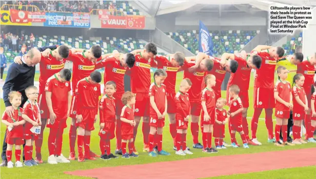  ??  ?? Cliftonvil­le players bow their heads in protest as God Save The Queen was played at the Irish Cup Final at Windsor Park last Saturday