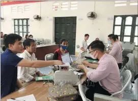  ?? ?? Cán bộ tín dụng Ngân hàng Chính sách xã hội huyện Lập Thạch trao đổi với người vay vốn tại điểm giao dịch xã Thái Hòa.
