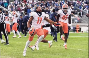  ?? Barry Reeger / Associated Press ?? Illinois wide receiver Carlos Sandy (11) and linebacker Khalan Tolson (45) celebrate their victory over Penn State in the ninth overtime Saturday.