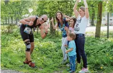  ??  ?? Familie Herrmann aus Langenau feuert den Papa beim Laufen an. Der stellt sich kurz in Pose, bevor er gleich wieder Gas gibt.