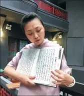  ?? WANG KAIHAO / CHINA DAILY ?? A musician shows off a book of musical scores of Nanyin, a traditiona­l music genre that still uses the gongchepu method.