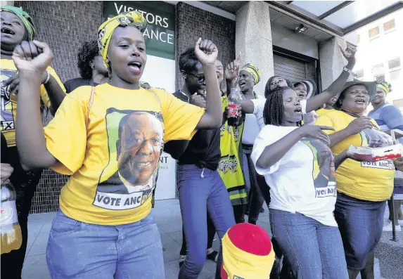  ??  ?? > Supporters of new president Cyril Ramaphosa singing and dancing in Cape Town, South Africa, yesterday