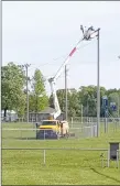  ?? COURTESY PHOTO ?? McDonald County Press NewMac crew members install new lights at the Goodman ball park.