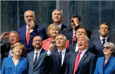  ?? FOTO: AP ?? En stribe topledere, herunder den danske statsminis­ter Lars Løkke Rasmussen, stiller op til gruppebill­ede ved Nato-topmødet.