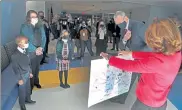  ??  ?? Gov. Charlie Baker and Lt. Gov. Karyn Polito got a welcome card from Sacred Heart students at the start of a tour of St. Mary’s in Lynn from, from left, first-grade student Edward Njuguna, Principal Kristina Relihan and fourth grader Bobbi Merryman.