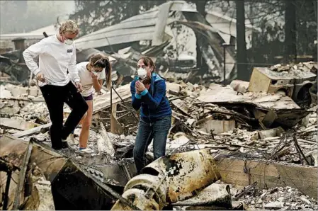  ?? JEFF CHIU/AP ?? Mary Caughey, right, reacts Tuesday after finding her wedding ring in the debris of her Sonoma County home, which was burned by wildfire.