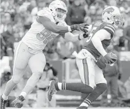  ?? ADRIAN KRAUS/AP ?? Buffalo Bills quarterbac­k Tyrod Taylor, right, eludes a tackle by Miami Dolphins defensive end Charles Harris during the first half last Sunday’s game in Orchard Park, N.Y.