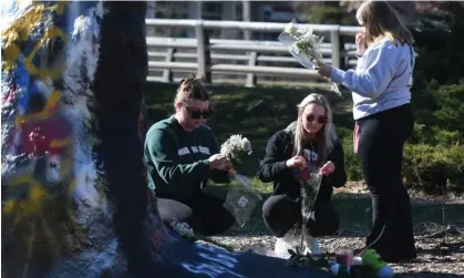  ?? Photograph: Usa Today Network/ Reuters ?? MSU students place flowers at a spot to commemorat­e the victims of the shooting on Monday night.