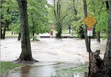  ?? LYNN KUTTER ENTERPRISE-LEADER ?? The creek at Creekside Park in Farmington looked like a roaring river Saturday. This is the concrete crossing. According to the National Weather Service, western Washington County received 8-9 inches of rain Friday and Saturday.