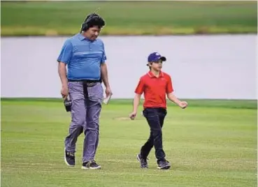  ?? PHELAN M. EBENHACK/ASSOCIATED PRESS ?? Notah Begay III, left, in his role with the Golf Channel, talks with Charlie Woods, son of Tiger, during the PNC Championsh­ip on Dec. 20. Begay’s latest project is creating a junior tour for young local golfers.