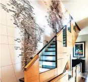  ??  ?? A custom two-story wallpaper map of the world fills the wall behind the main stairway.