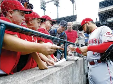  ?? DUANE BURLESON / GETTY IMAGES ?? The Reds’ Eugenio Suarez signs autographs for fans before Wednesday’s game against the Tigers at Comerica Park. Cincinnati starter Sal Romano (6-9) allowed four runs and eight hits in 5⅓ innings.