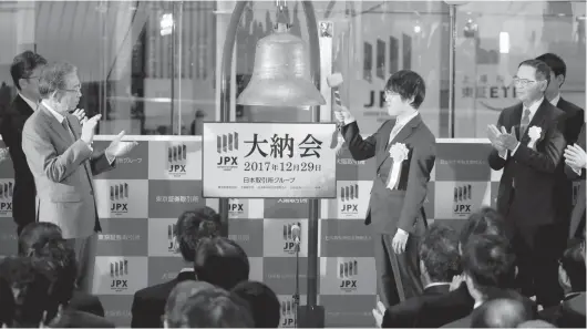  ?? — Reuters ?? Yuta Iyama, a champion of the board game Go, rings a bell during a ceremony marking the end of trading in 2017 at the Tokyo Stock Exchange in Tokyo, December 29, 2017.