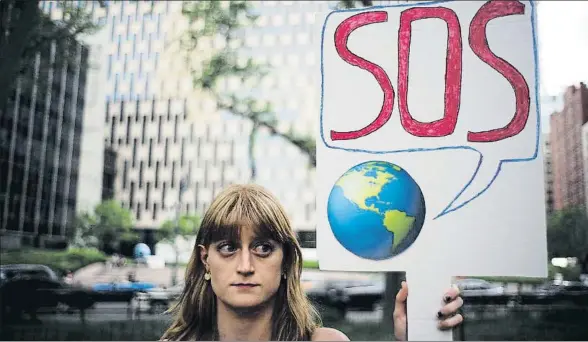  ?? JEWEL SAMAD / AFP ?? Una mujer protesta en Nueva York contra la decisión del presidente Trump de retirar a su país del acuerdo del clima de París