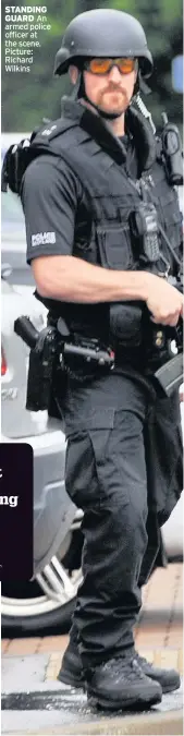  ??  ?? STANDING GUARD An armed police officer at the scene. Picture: Richard Wilkins