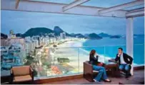  ??  ?? File photo shows tourists sit in a bar at a hotel overlookin­g Copacabana beach, in Rio de Janeiro, Brazil.