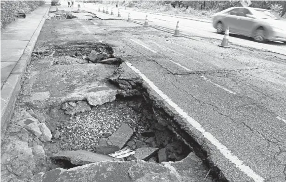  ?? KARL MERTON FERRON/BALTIMORE SUN PHOTOS ?? The roadbed shows evidence of being scoured by the force of water flowing down Frederick Avenue, west of Wyndholme Way in the Beechfield community.